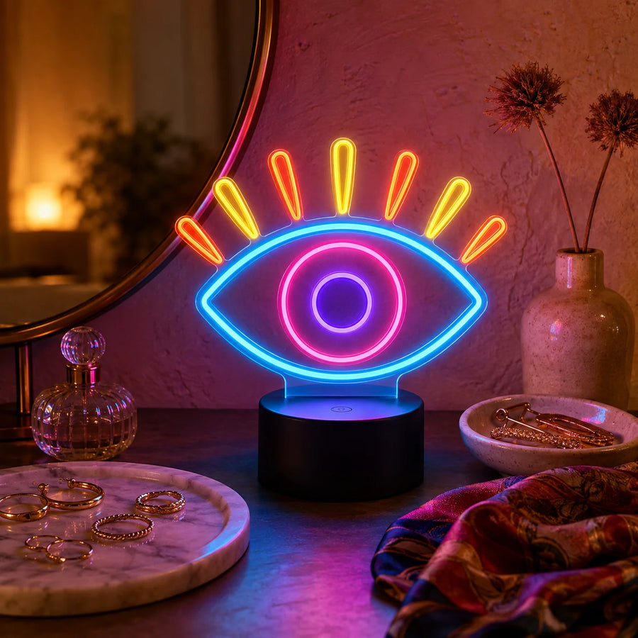 Evil eye neon desk light glowing on a vanity beside jewellery and a mirror