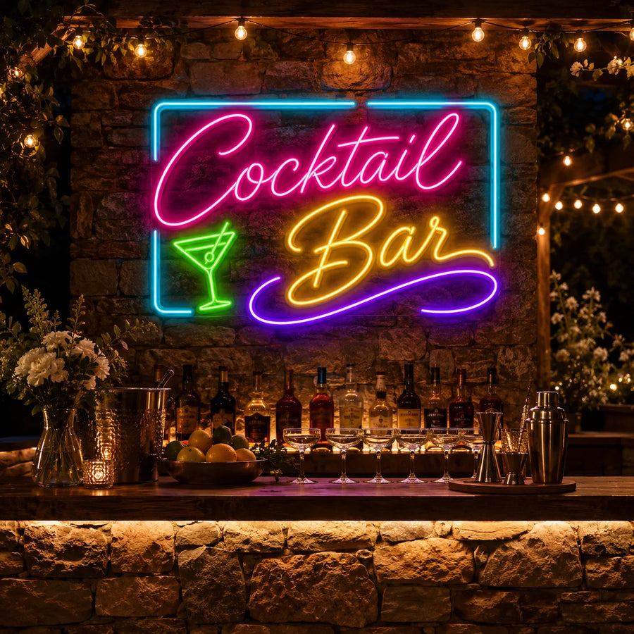 Cocktail Bar neon sign on a stone wall above an outdoor garden bar