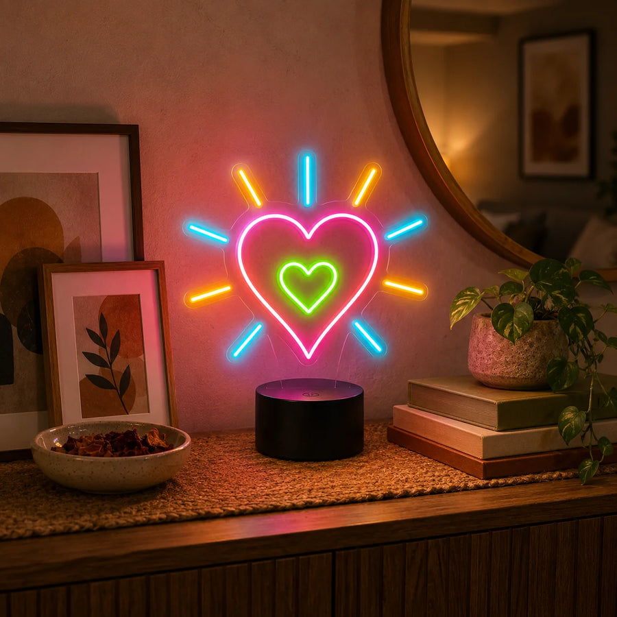 Heart neon desk light with rays glowing on a console table beside framed prints