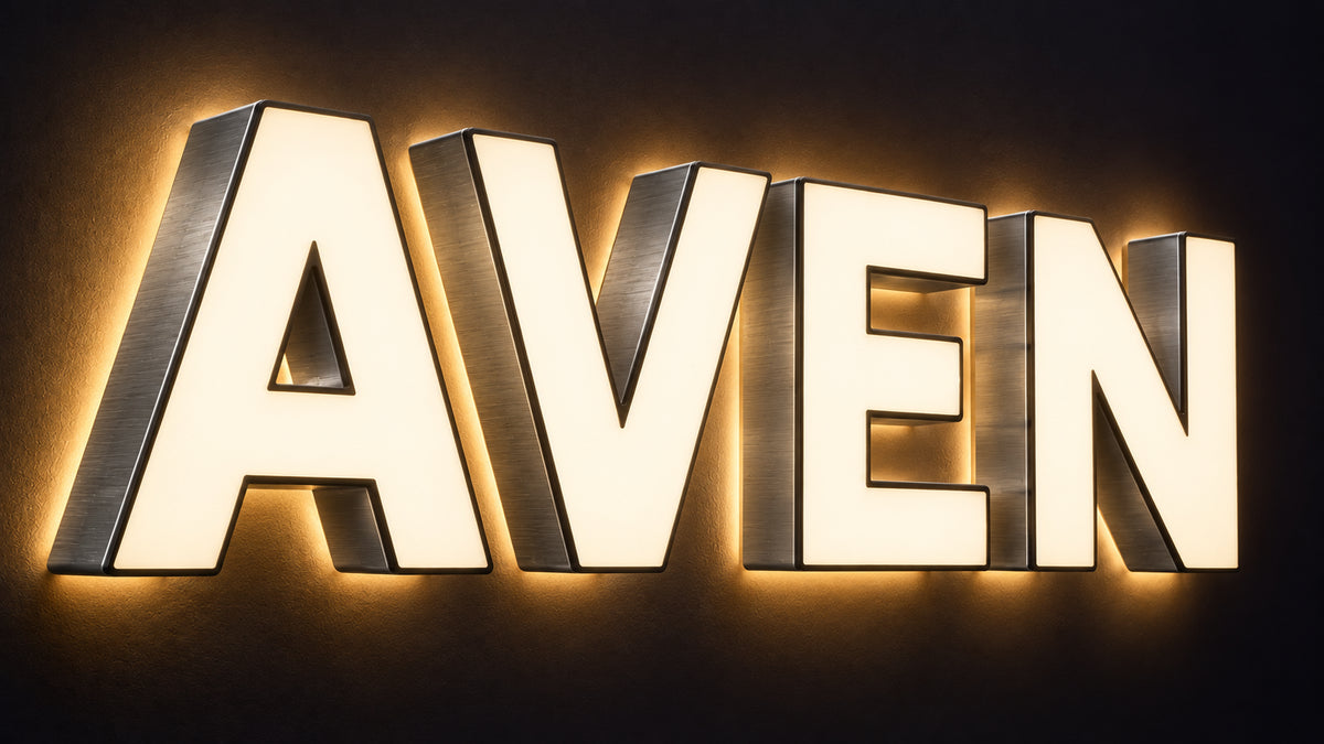 Combination front-lit and halo-lit channel letter sign spelling AVEN, glowing at the face and on the wall behind