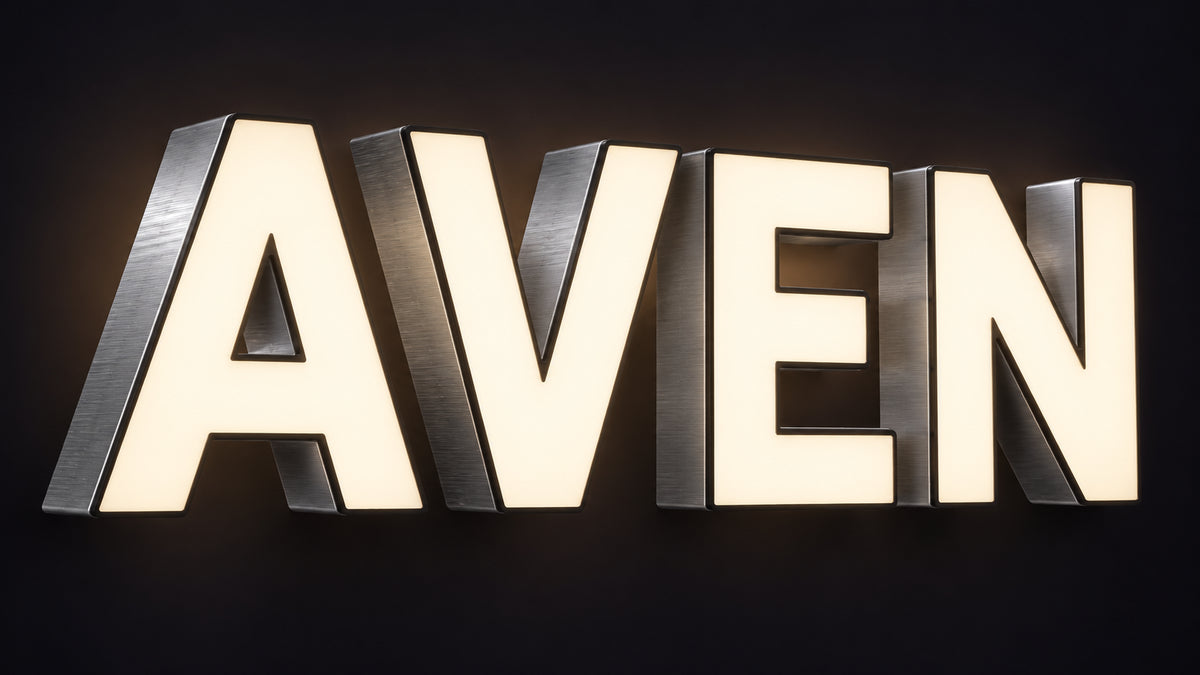 Front-lit LED channel letter sign spelling AVEN with glowing warm white acrylic faces and brushed aluminium returns