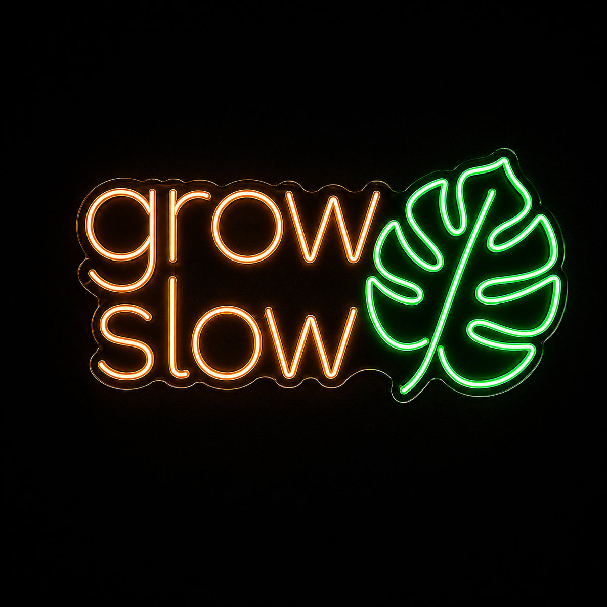 Grow Slow LED neon sign with monstera leaf by Fineyst Neon in Orange & Green on clear acrylic