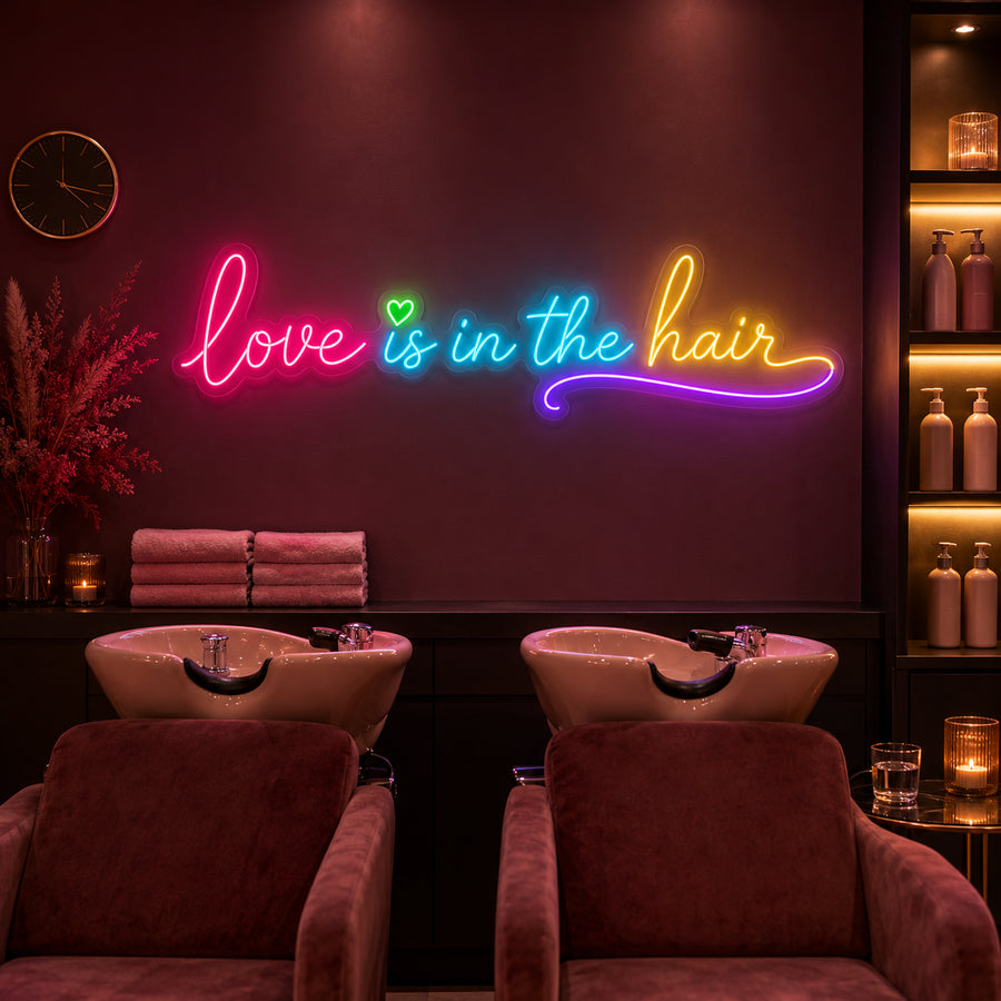 Love Is In The Hair neon sign glowing above a salon wash station
