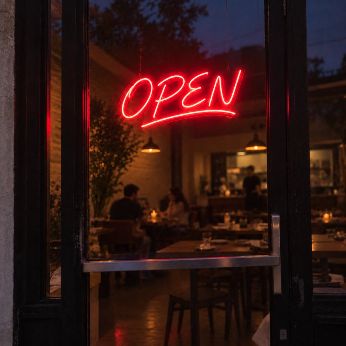 Red OPEN LED neon sign hanging in a restaurant door window