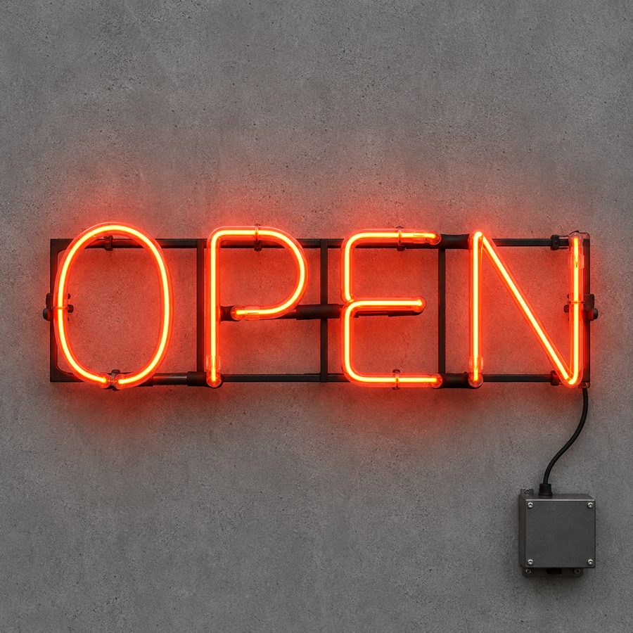 Traditional hand-bent glass neon OPEN sign with visible electrodes and transformer on a concrete wall.